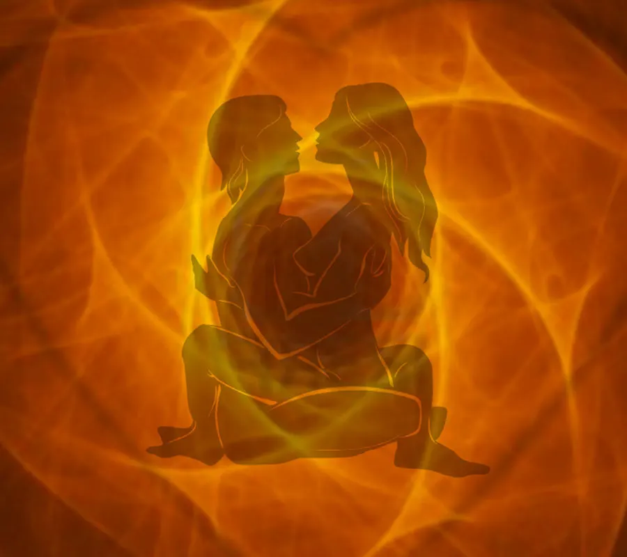 Silhouettes d'un couple enlacé sur fond orangé, sexothérapie